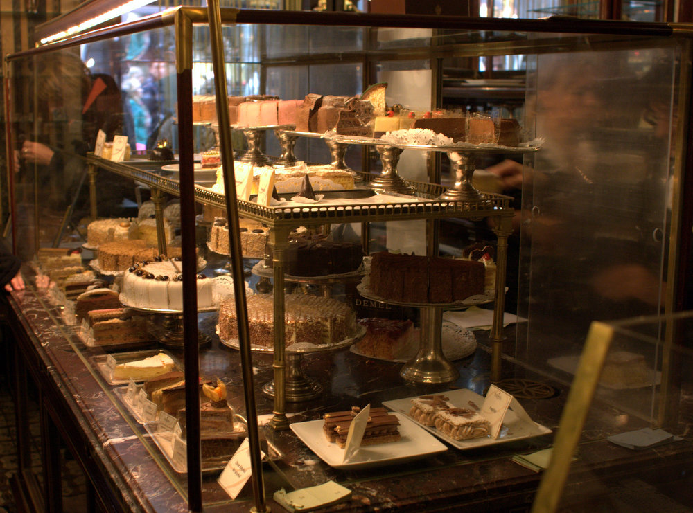 a store window filled with cakes and bundt cakes