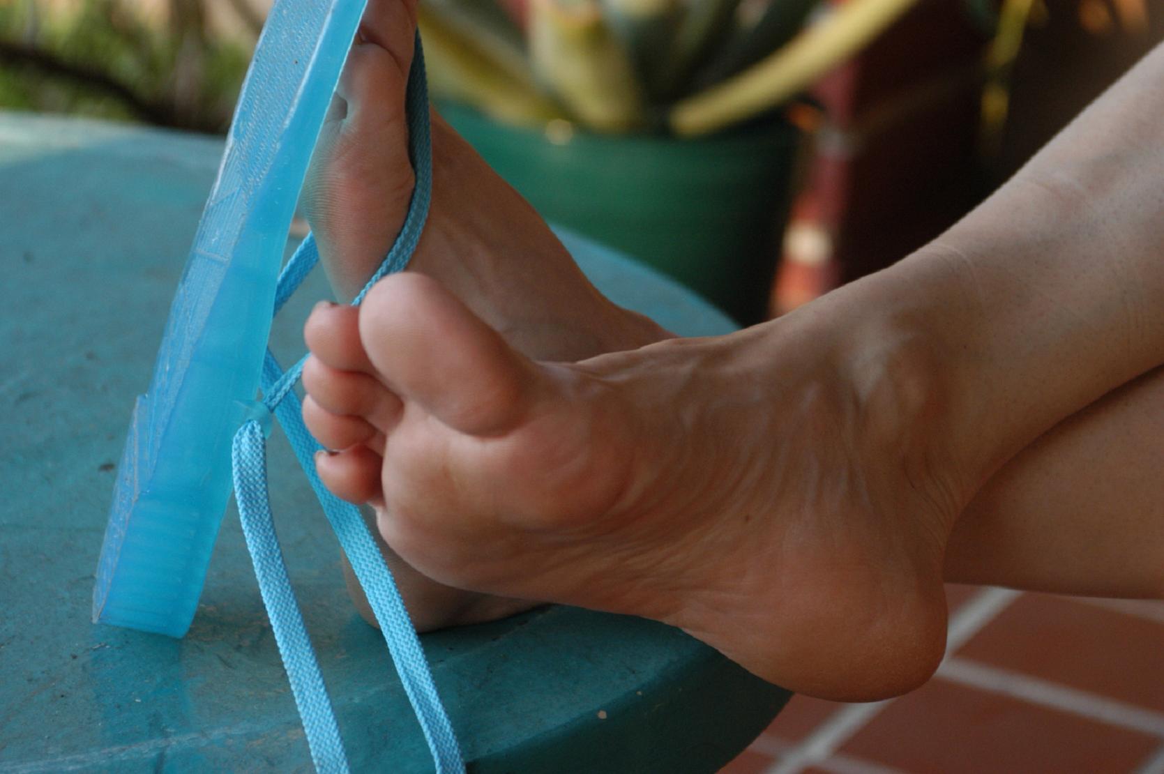 a person sitting down with a blue ribbon around their feet