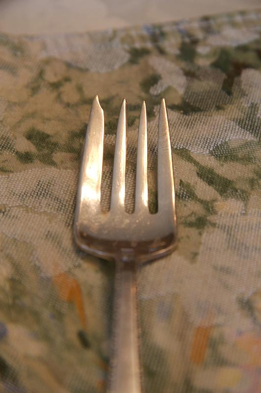 a couple of forks sitting on top of a floral cloth