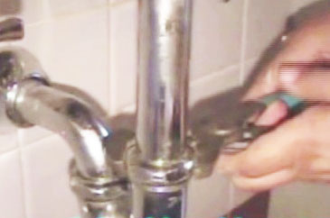 a person is fixing the hole in a bathroom faucet