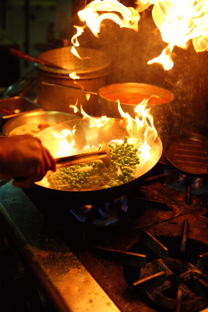 a group of people cooking food on top of a stove