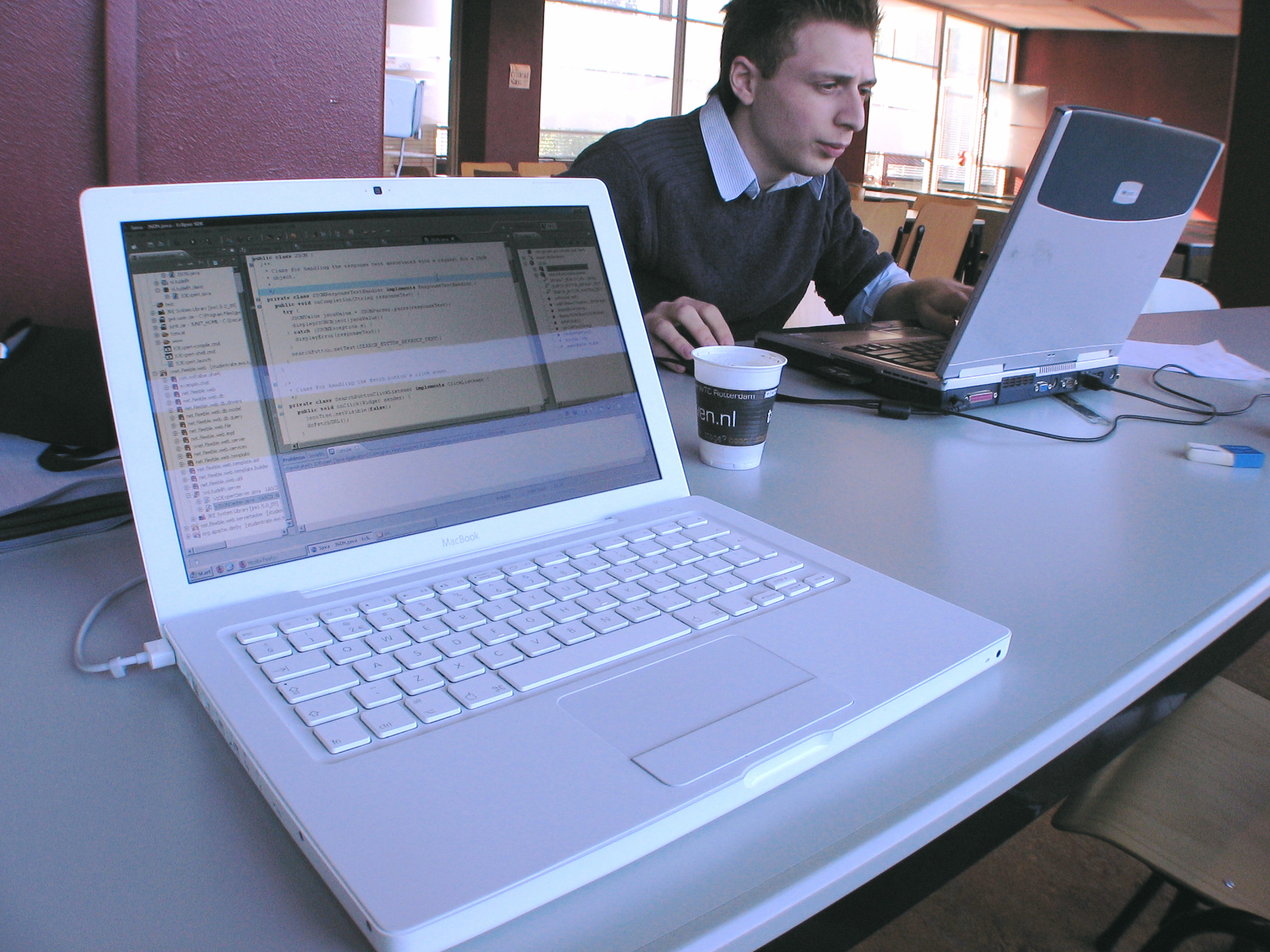 man using laptop in coffee shop at work