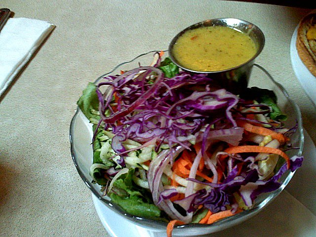 bowl of salad with dressing sitting on a counter