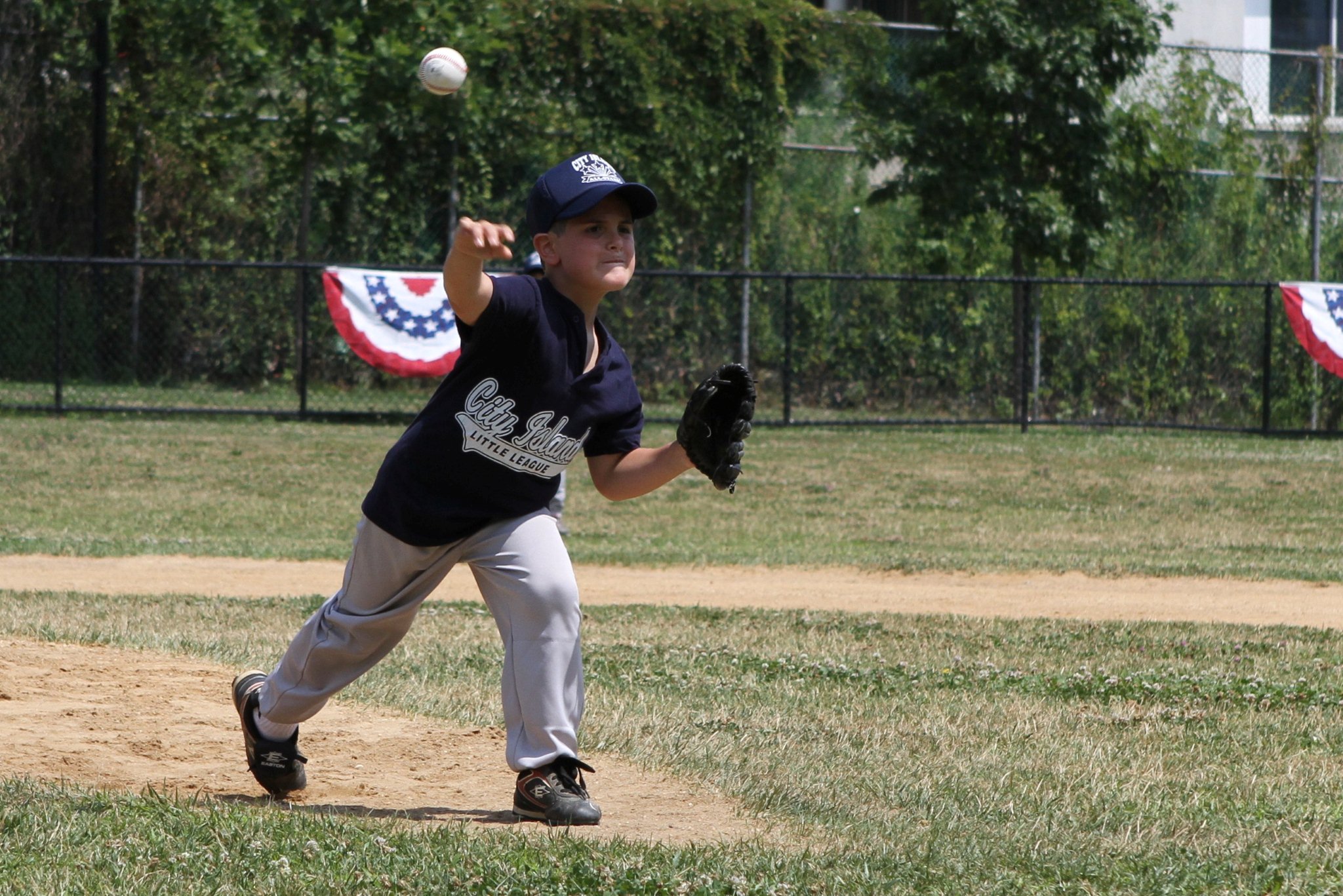 a little league baseball player is winding up for the throw