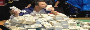 a man holding a money sign in front of stacks of cash