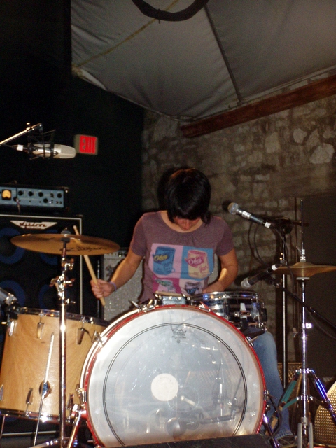 a person with drums and a set of microphones