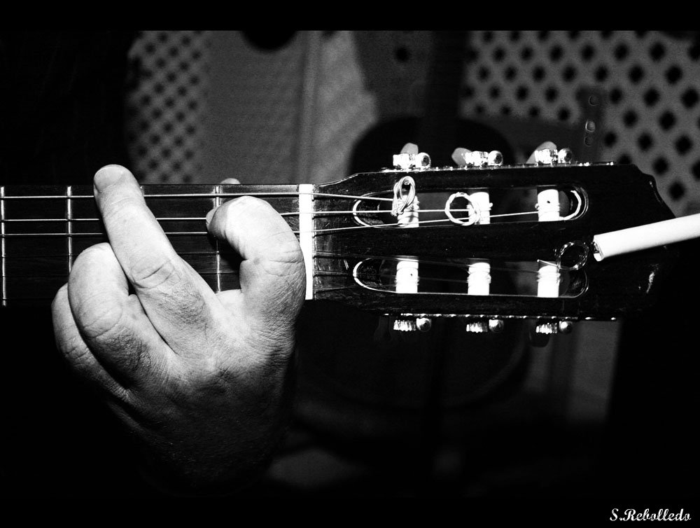 person playing a guitar in black and white
