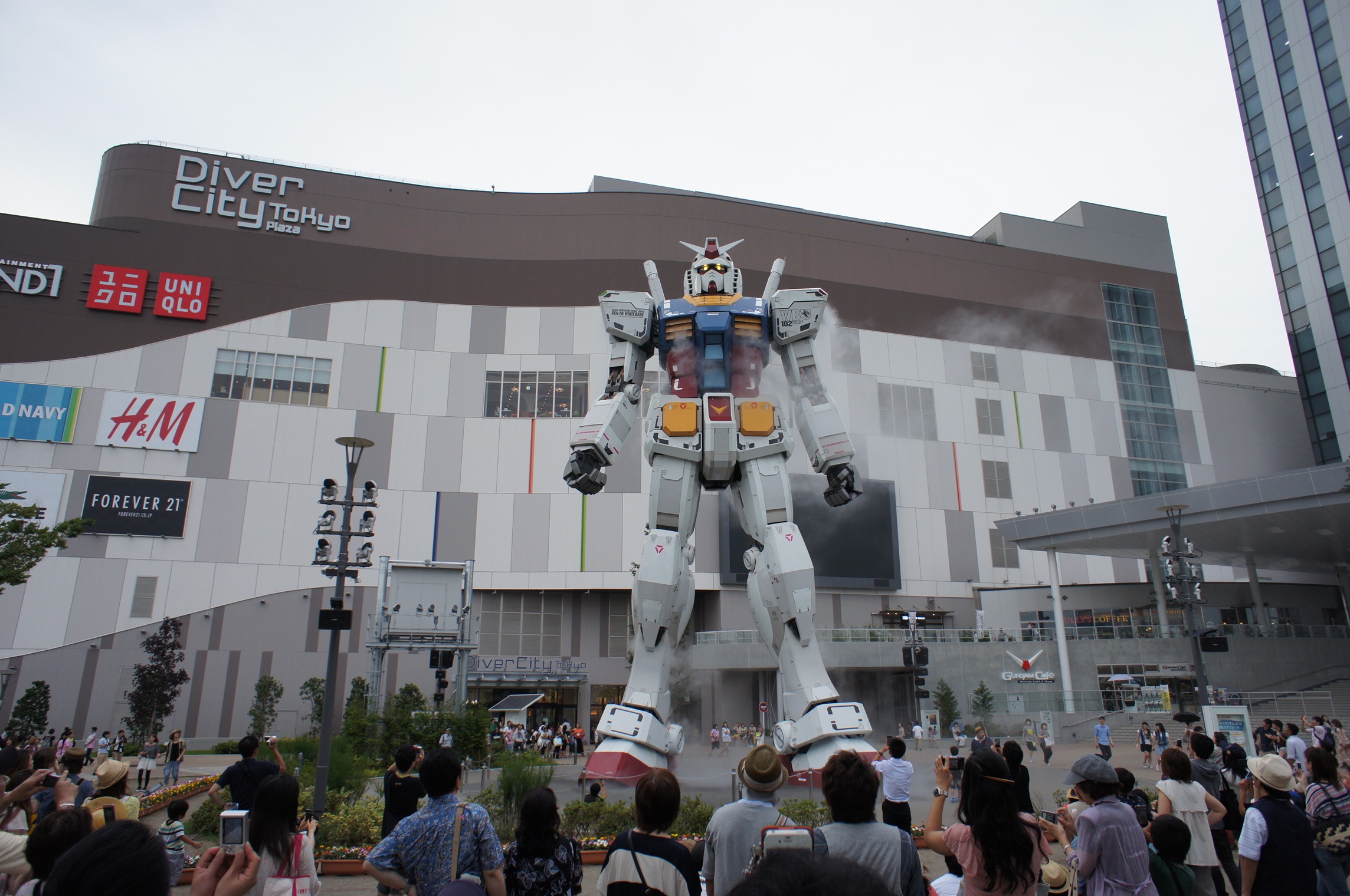 a giant robot statue outside a modern building