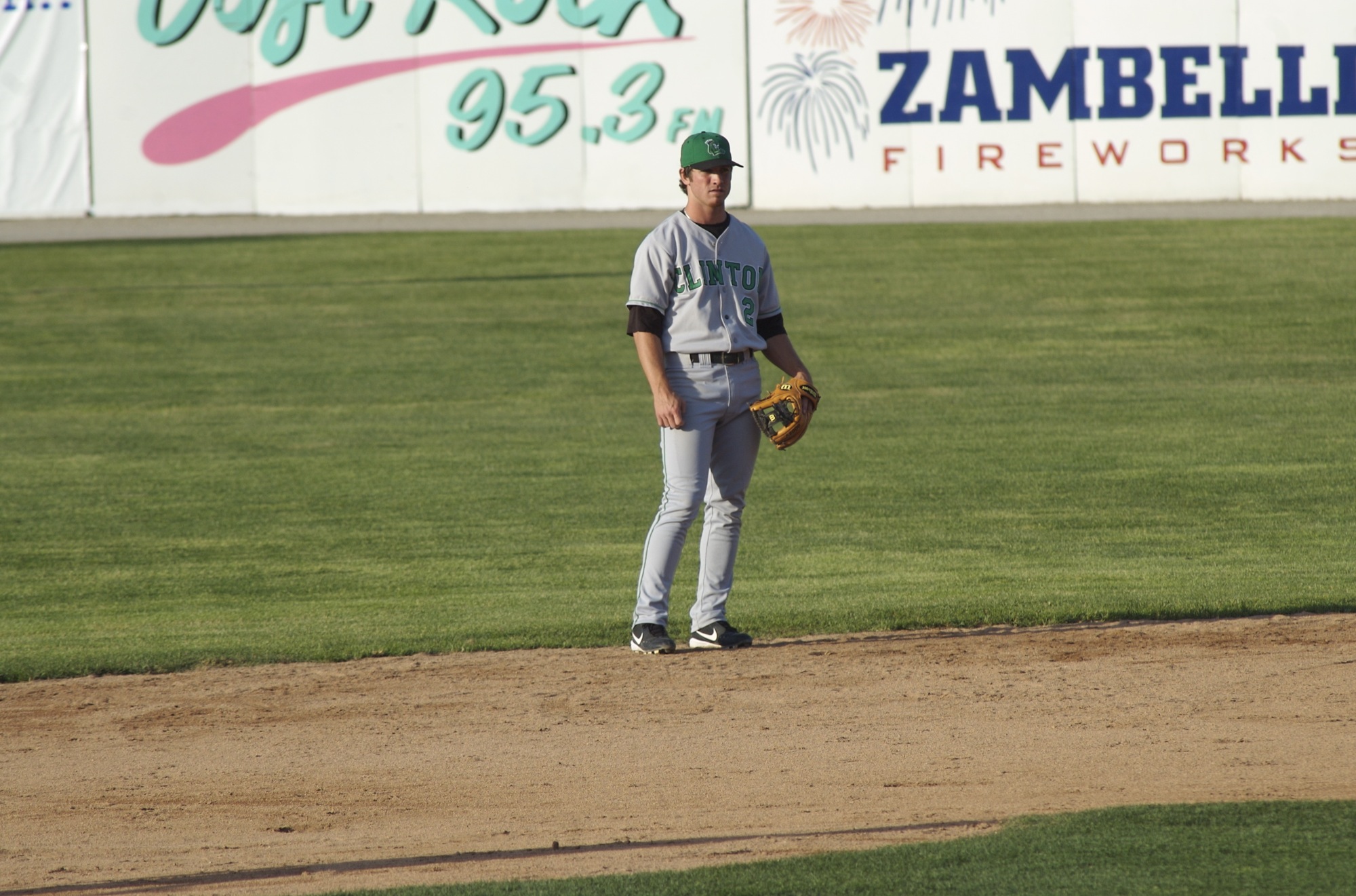 a baseball player standing at the base line waiting