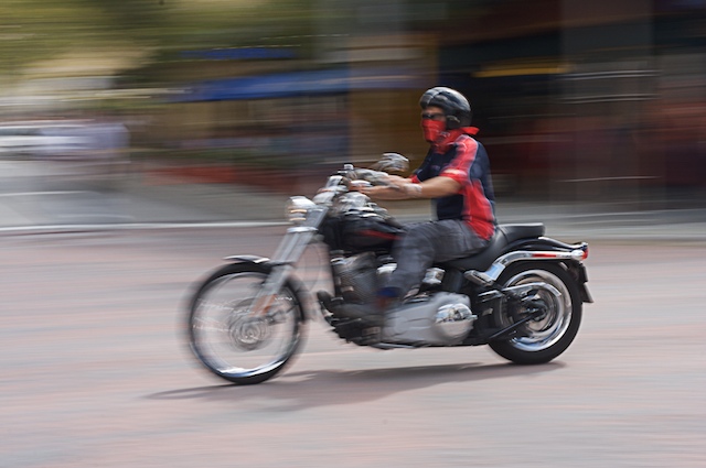 a person on a motorcycle driving down a street