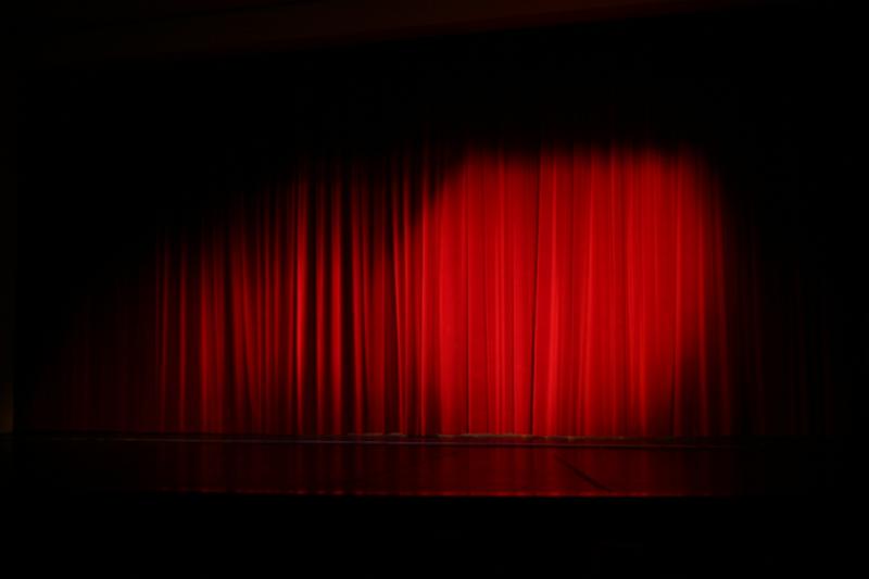 a large, red curtain sits on top of a stage