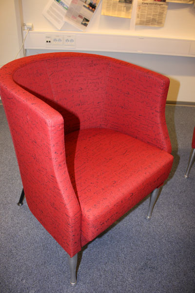 a red chair is set up in front of a shelf