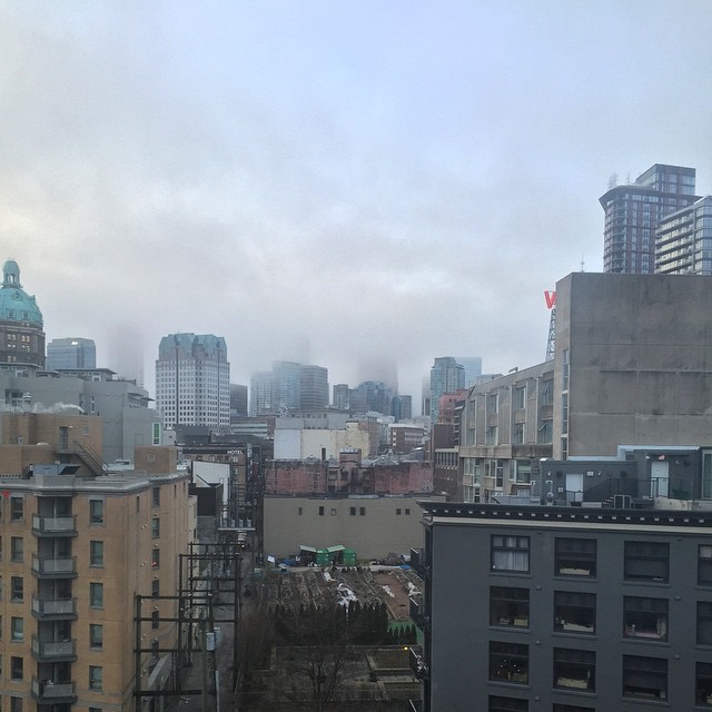 the city skyline is shown with buildings in fog