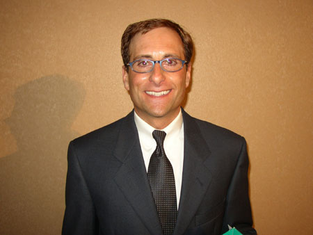 a close up of a person wearing glasses and a suit