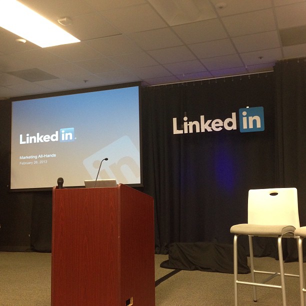 an empty office auditorium with a man speaking at the top