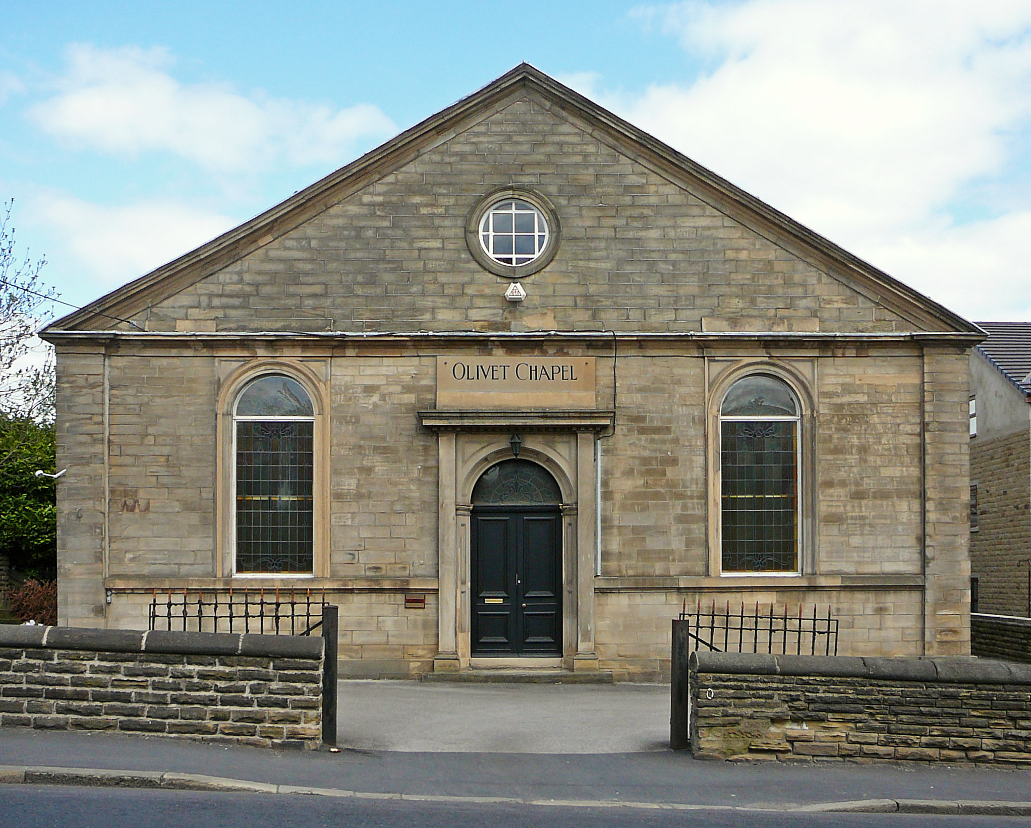 a small building with windows and a gate in front of it