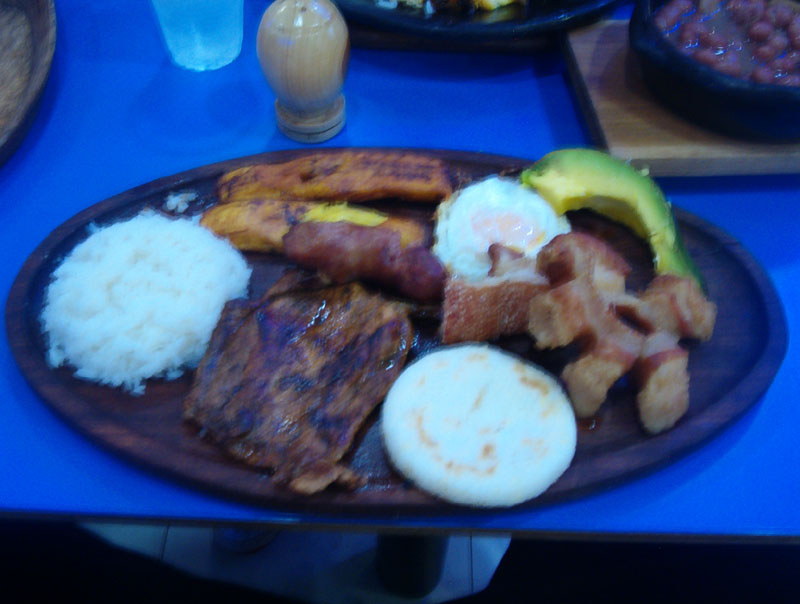 a plate topped with ribs, potatoes and bacon