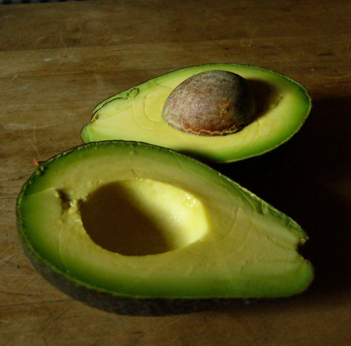 an avocado cut in half on a  board