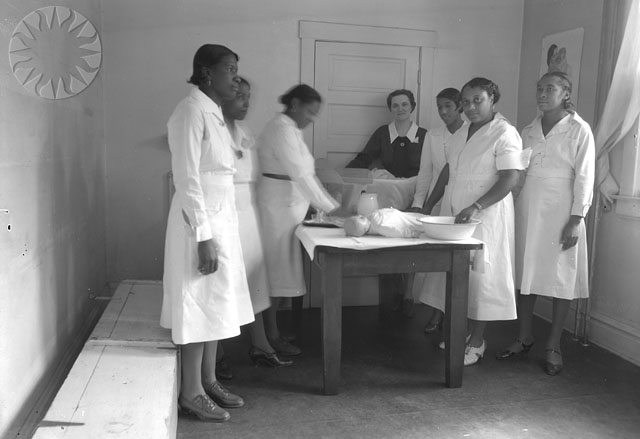 old black and white pograph of people in scrubs  an object