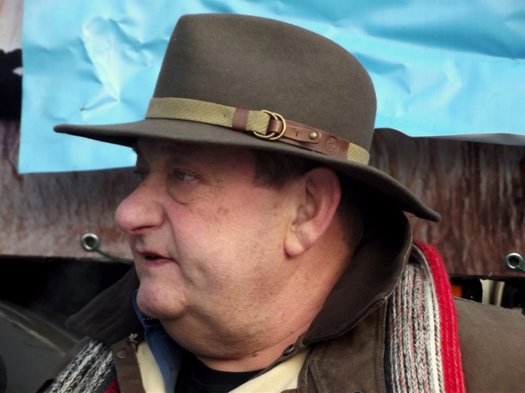 a man in a top hat and jacket at a sporting event