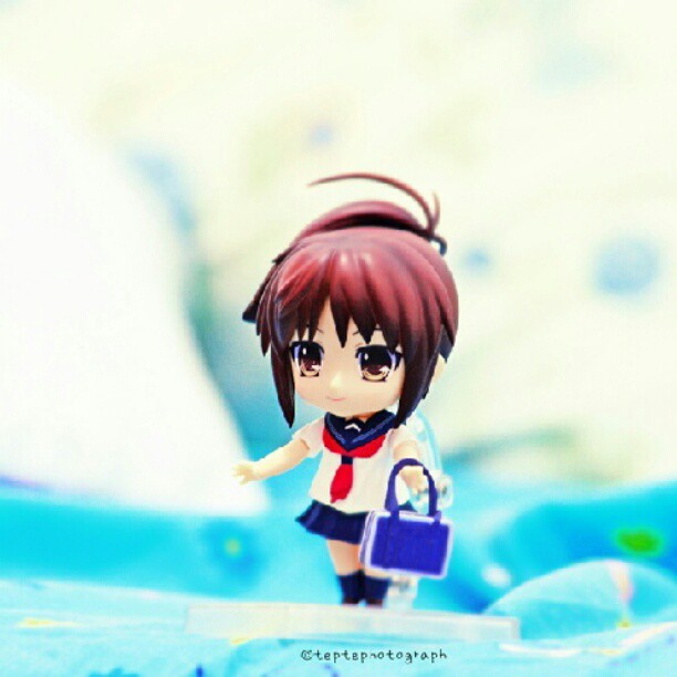 a doll of a young anime girl holding a bag