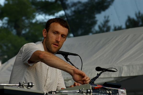 a man playing music at an outdoor music festival