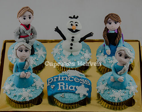 a decorated tray with four frozen princess cupcakes