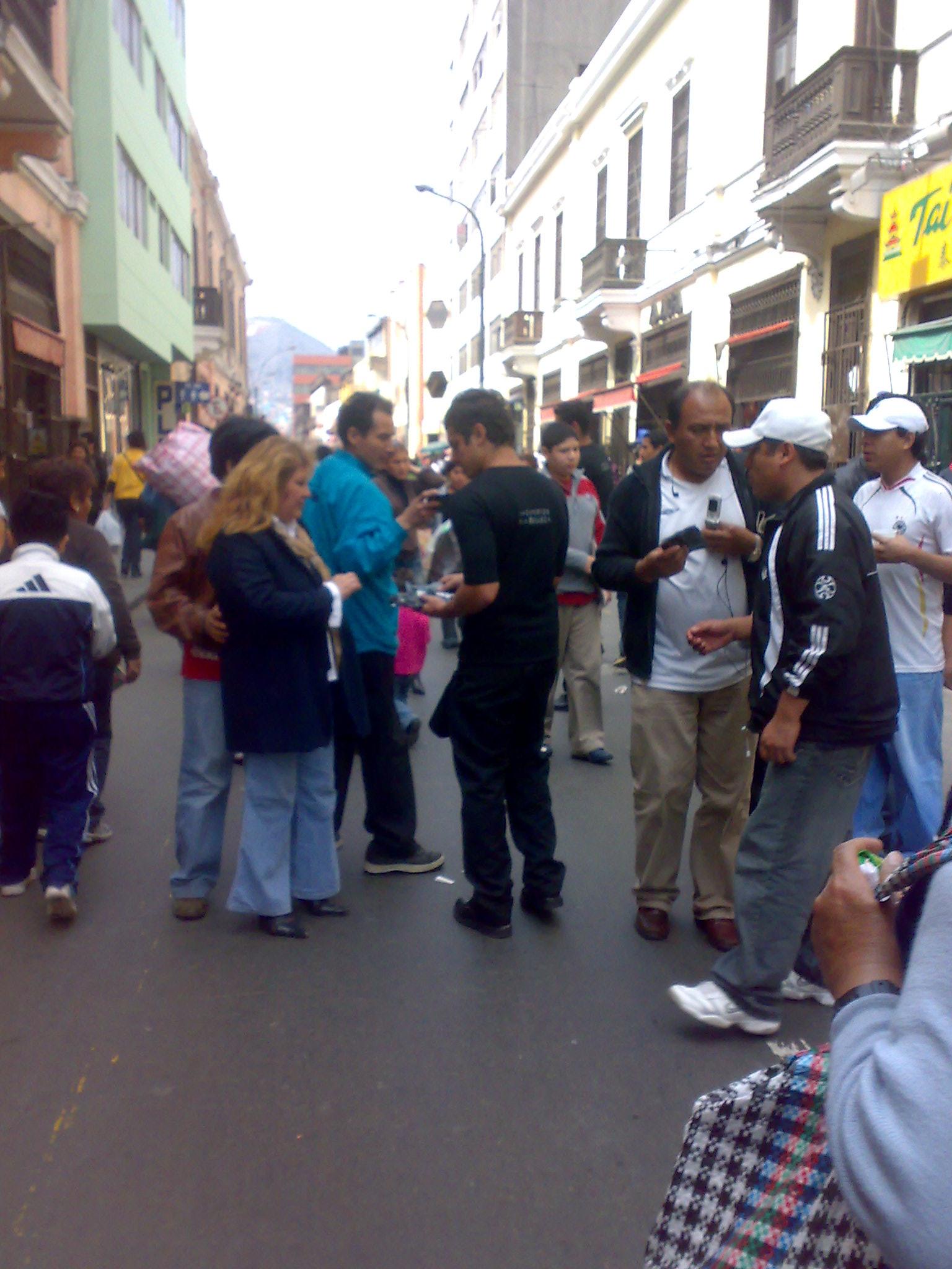 people on a street taking pictures of each other