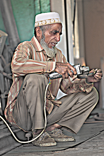 a man sitting on the ground looking at a cell phone