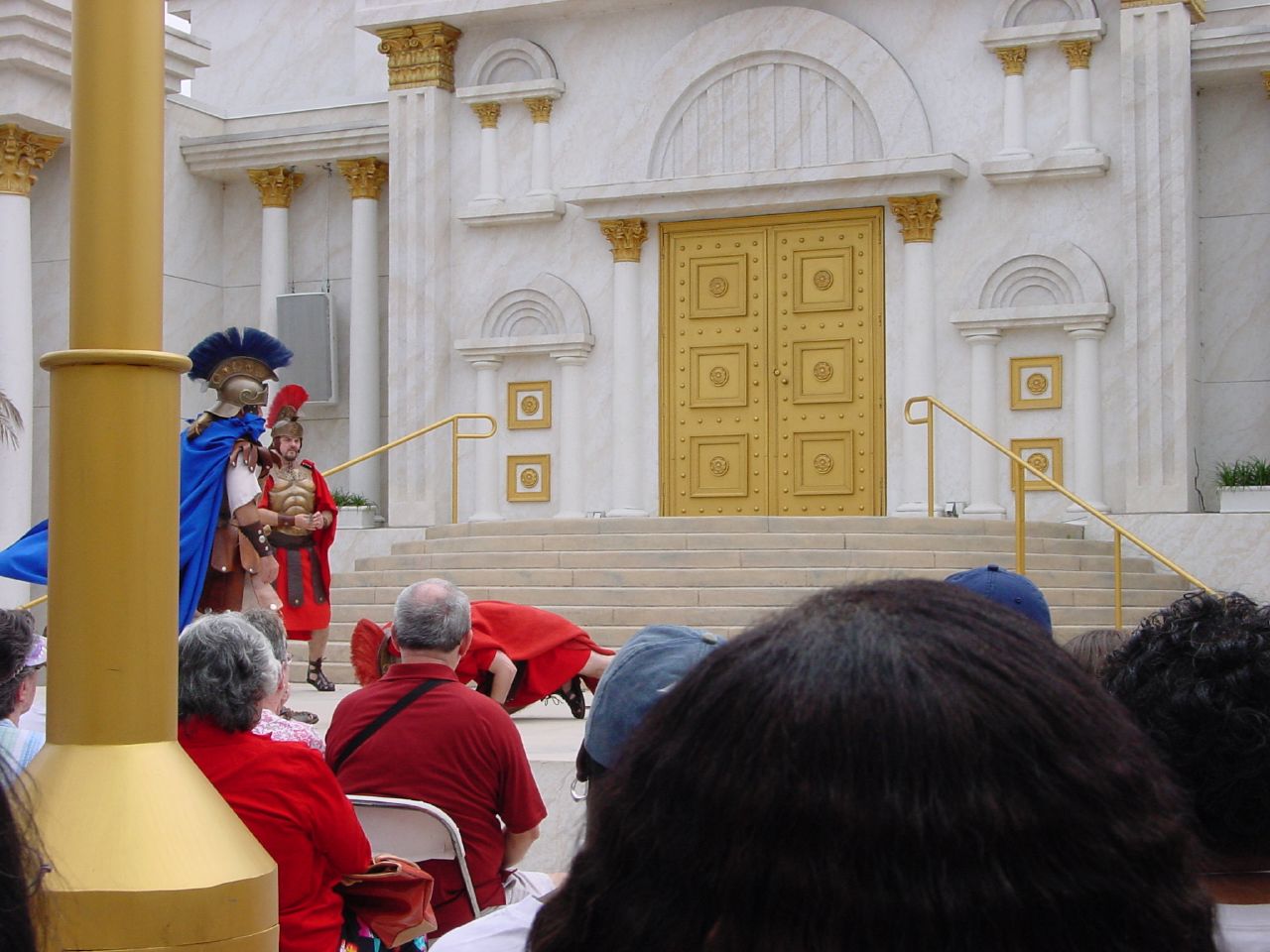 a person in red and blue stands with a microphone to someone in white