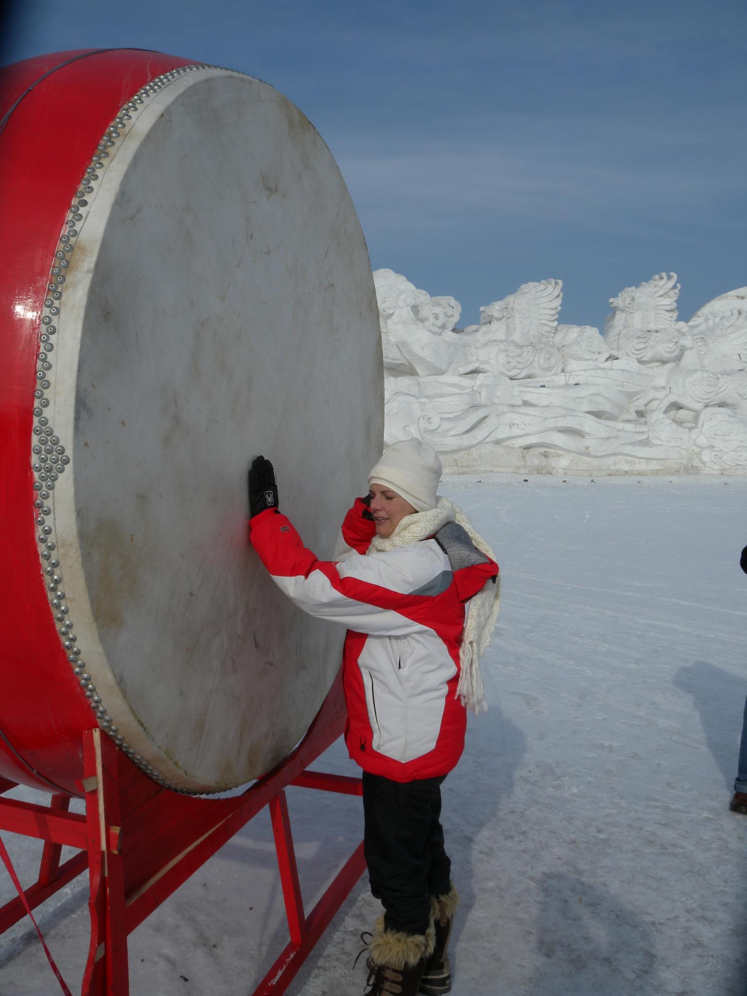 two men standing in front of a large drum