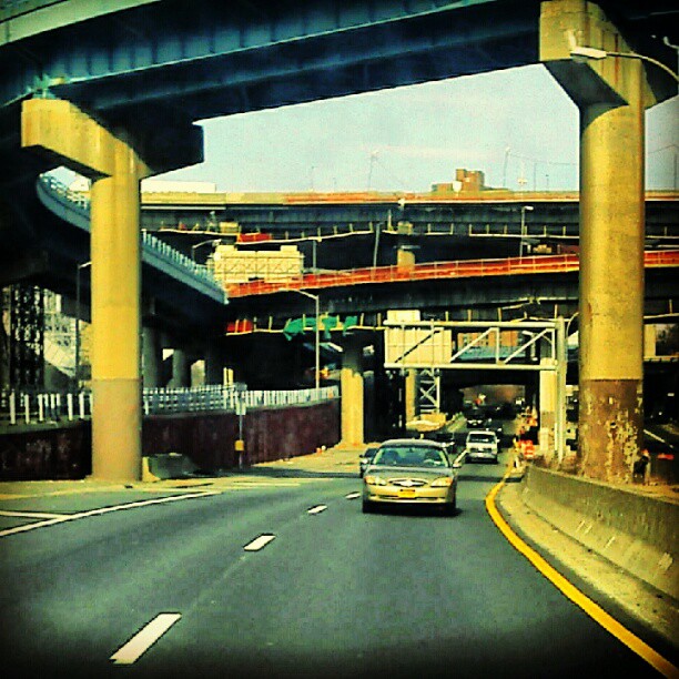 a car driving underneath an overpass on a city street