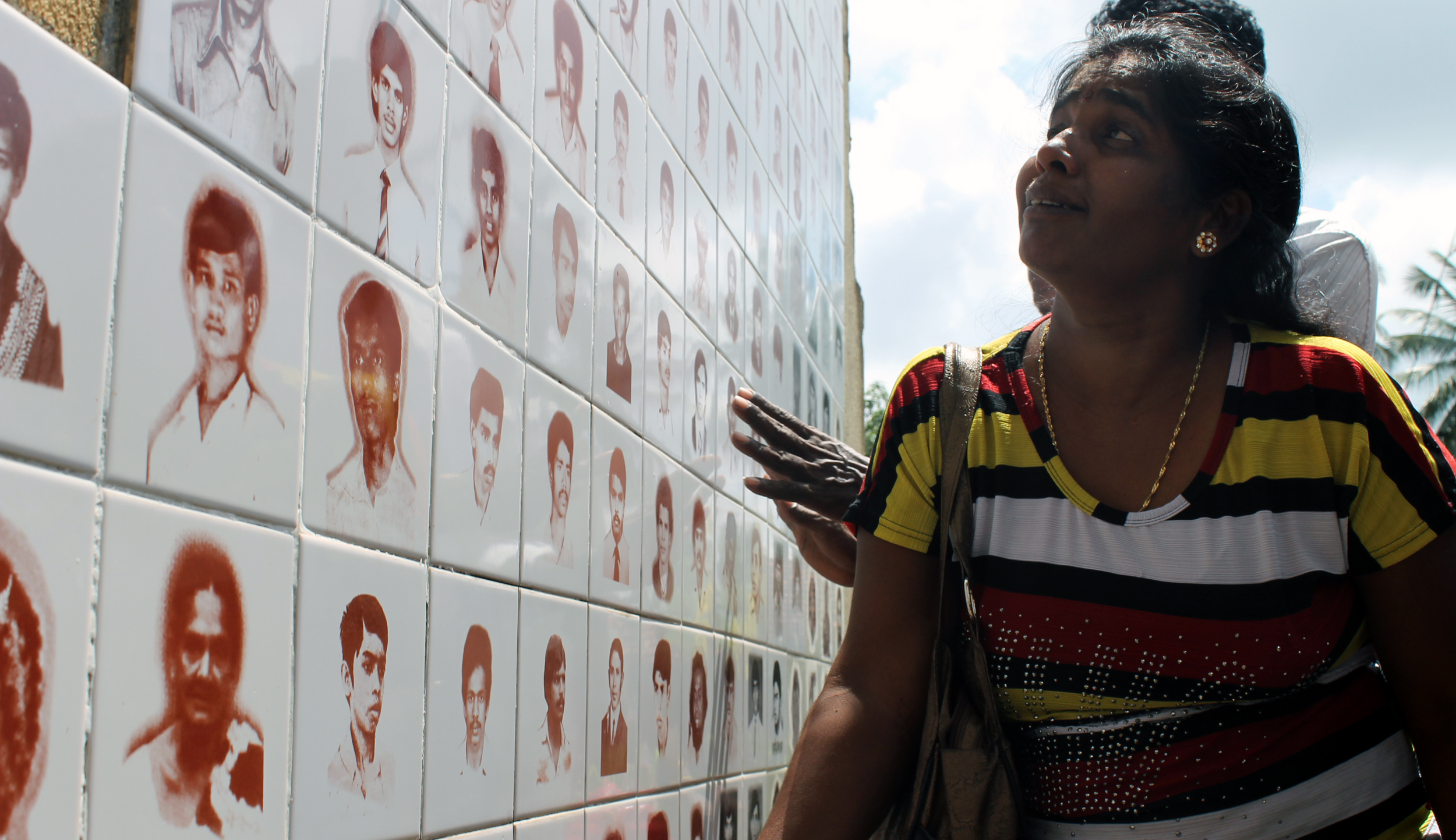 a woman standing near several different types of skull images on a wall