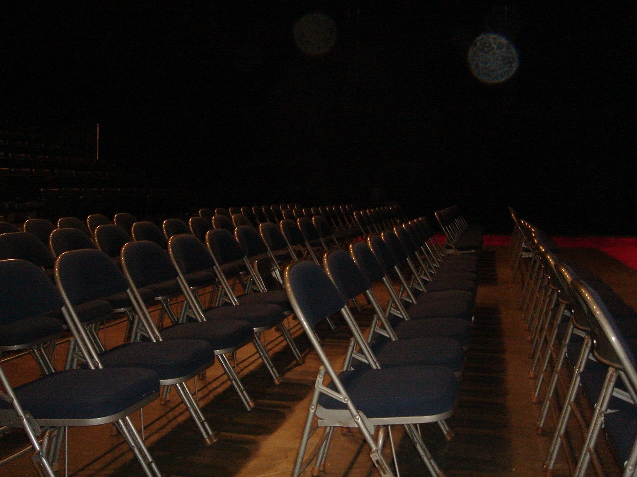 rows of chairs in an empty stage at night