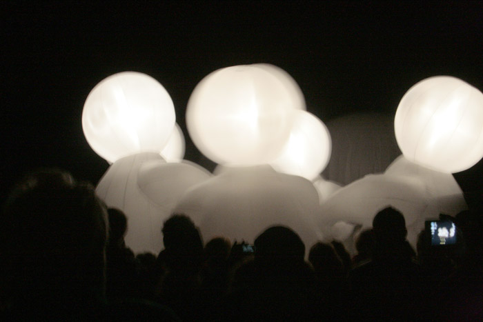 large white balloons are floating at an event