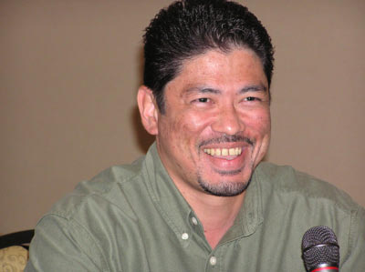 an asian man is holding a microphone in his lap