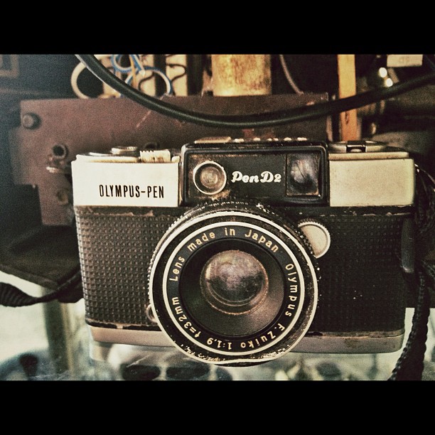 an old camera sitting next to wires and a chain