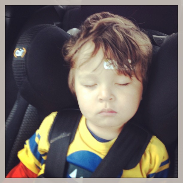 little boy sleeping in the back seat of a car