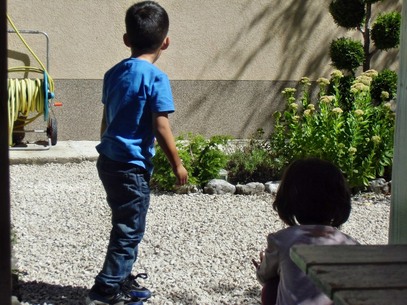 two young children playing outside together in the sun