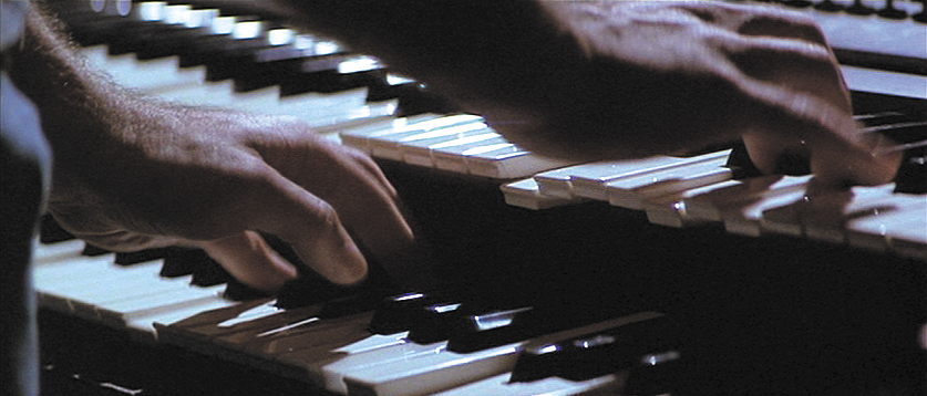 two hands are playing an electronic organ together