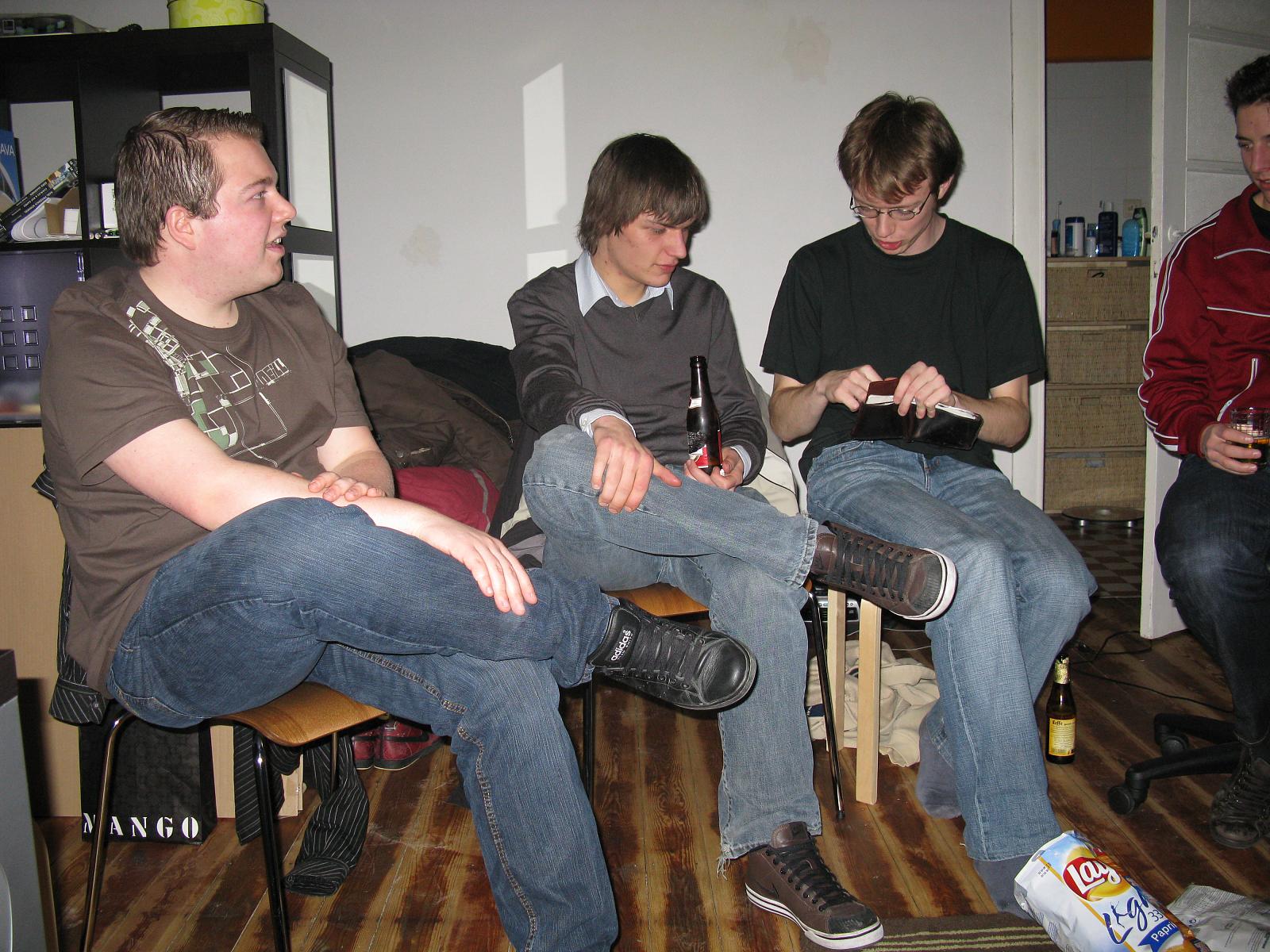 four people sitting together one is playing a game