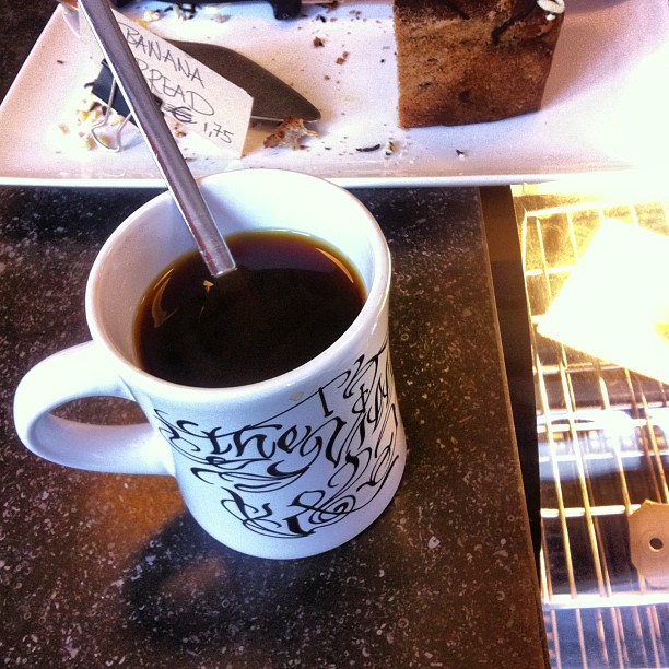 the cup is full of black coffee and brownies