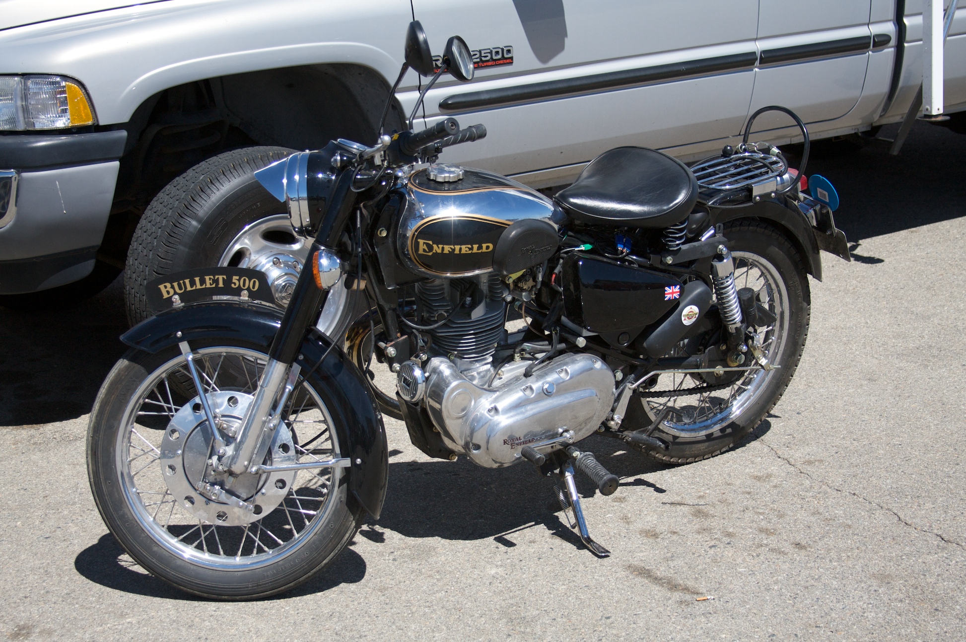 a motorcycle parked next to a truck on a road