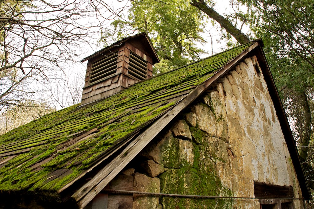 the old building has moss growing on it's roof