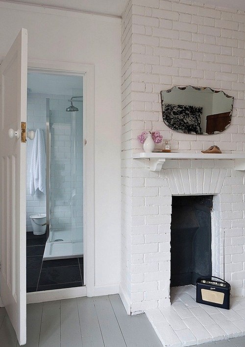 there is an empty fireplace with white walls and white floors