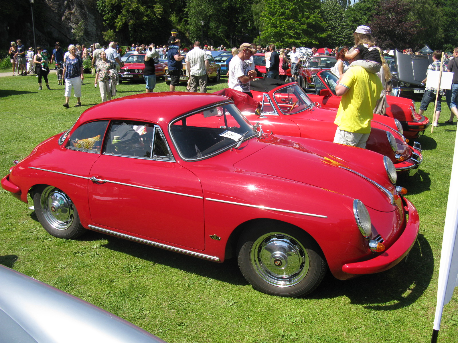 classic cars are sitting on the grass near a crowd