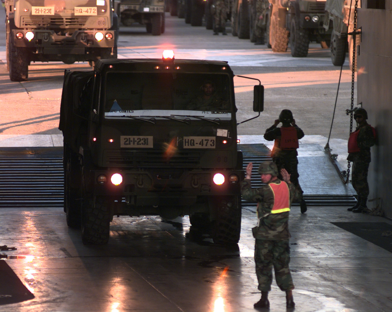 some men standing next to some very big trucks