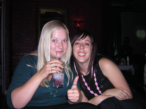 two young women are having drinks in their glasses