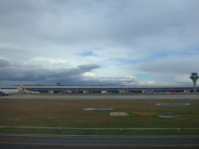 a plane that is on the runway under clouds