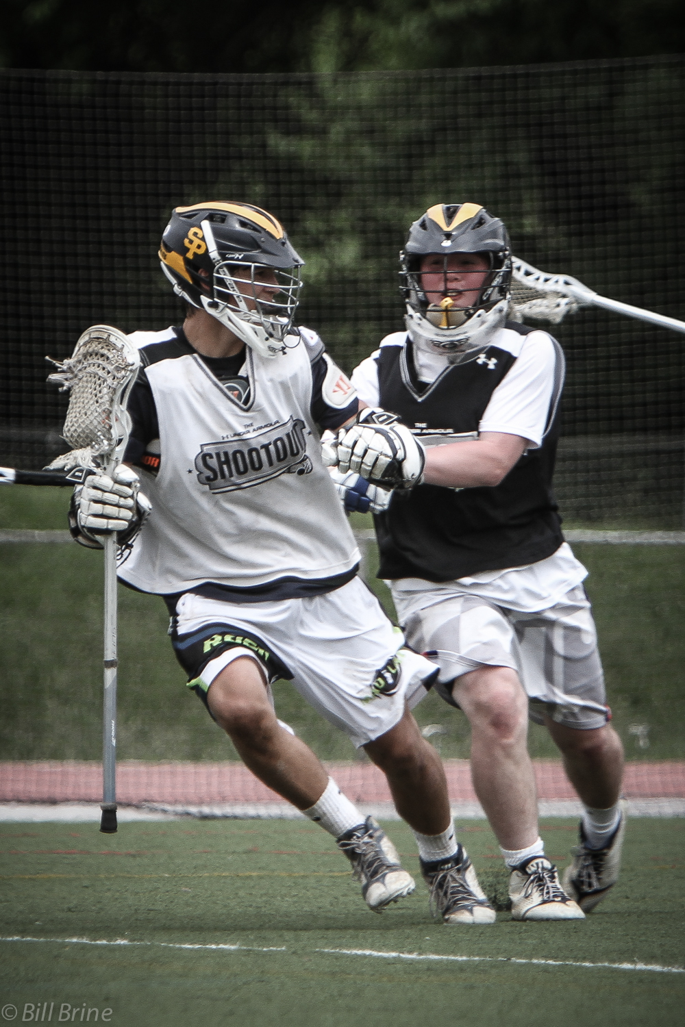 a couple of young men playing a game of lacrosse